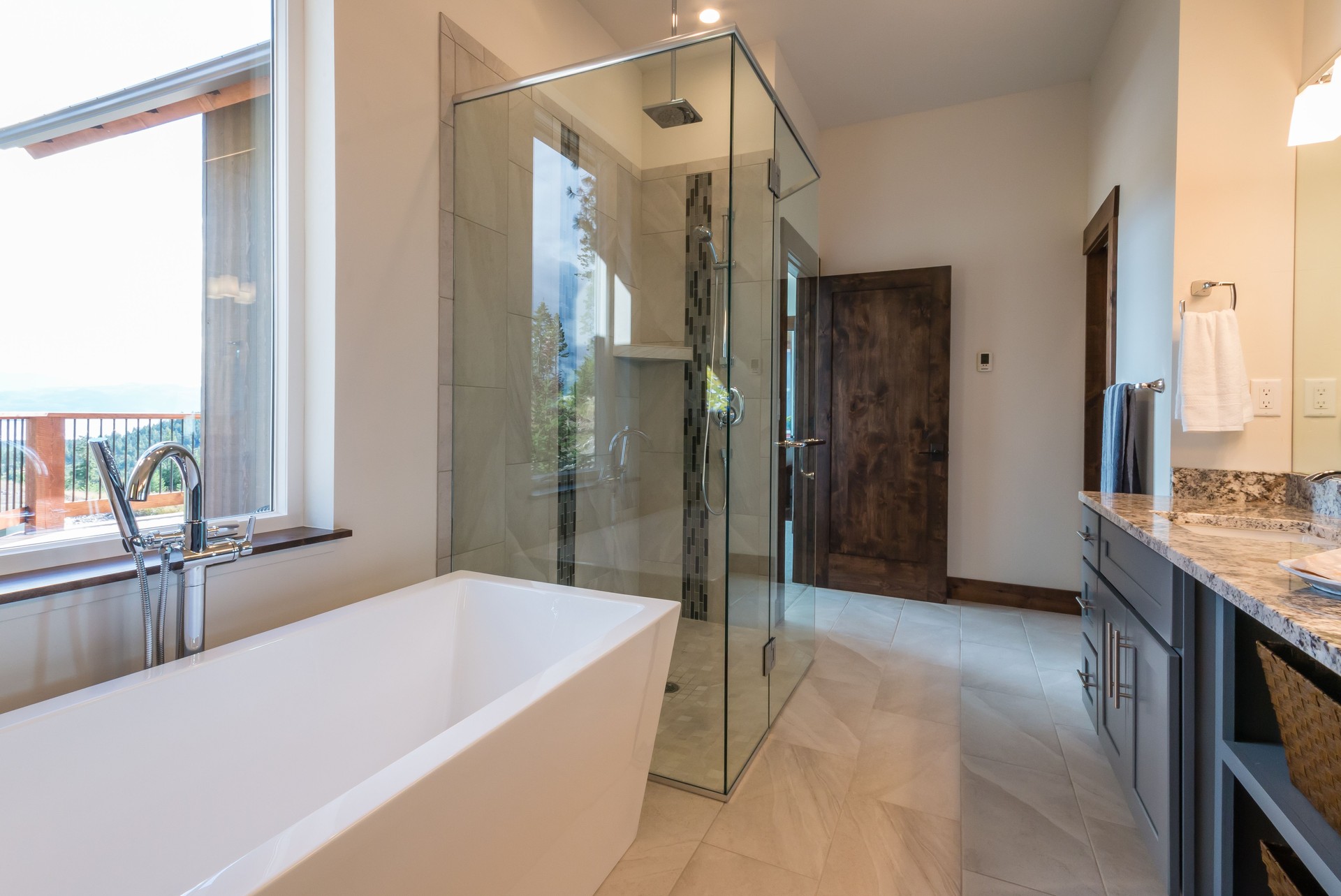 Long freestanding tub with standing faucet in bathroom